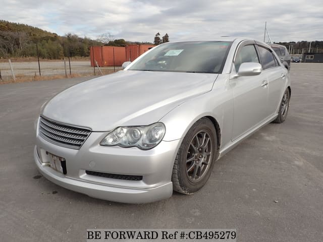 A grey JDM sports car speeding down a highway at night.