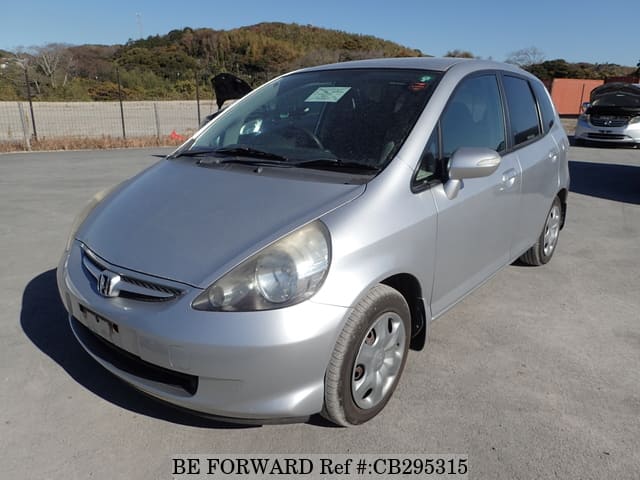 A grey JDM sports car speeding down a highway at night.