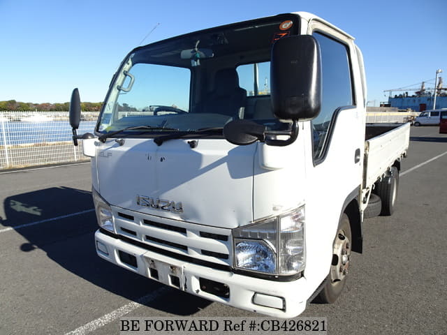 A grey sports car speeding down a highway at night.