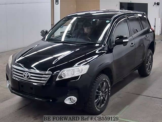 A grey sports car speeding down a highway at night.