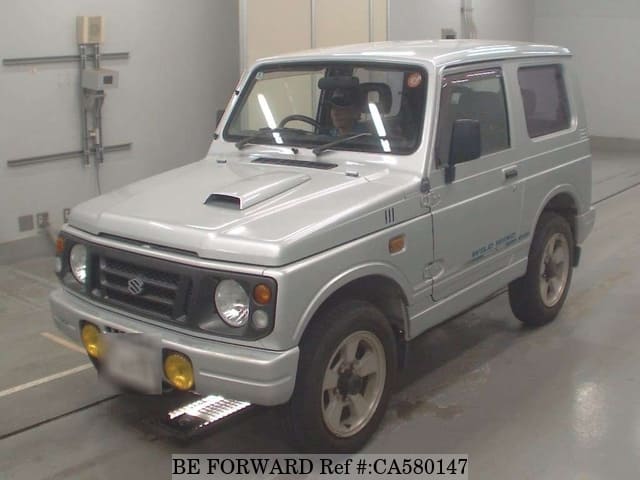 A grey JDM sports car speeding down a highway at night.
