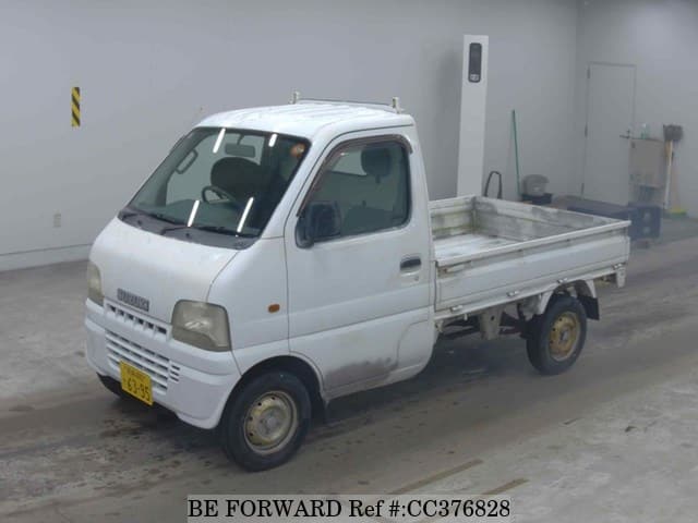 A grey sports car speeding down a highway at night.