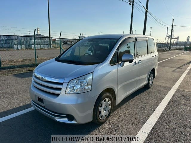 A grey sports car speeding down a highway at night.