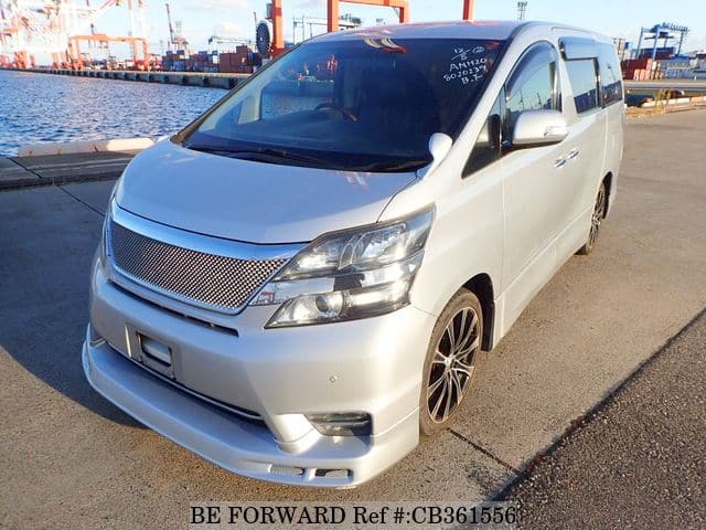 A grey JDM sports car speeding down a highway at night.