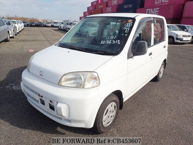 A grey JDM sports car speeding down a highway at night.