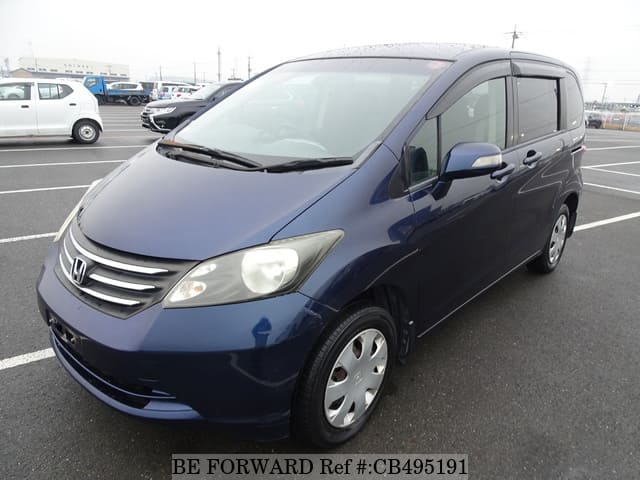 A grey JDM sports car speeding down a highway at night.