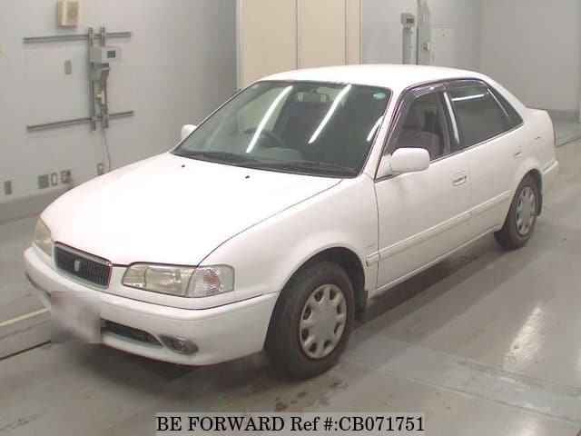 A grey JDM sports car speeding down a highway at night.