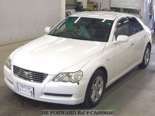 A grey JDM sports car speeding down a highway at night.
