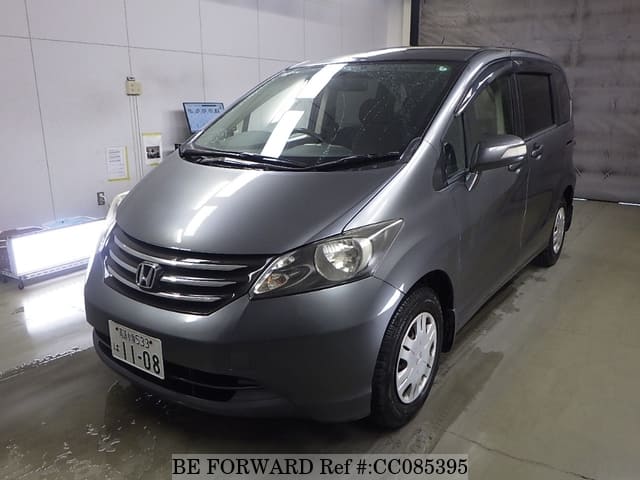 A grey sports car speeding down a highway at night.
