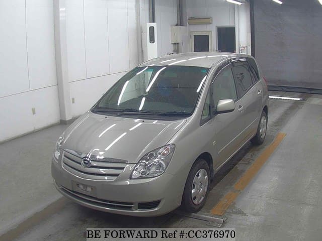 A grey sports car speeding down a highway at night.