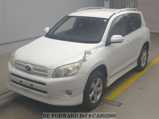 A grey JDM sports car speeding down a highway at night.