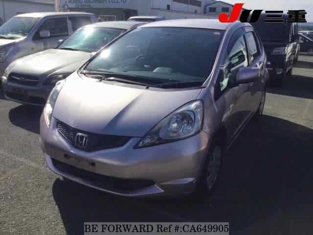 A grey JDM sports car speeding down a highway at night.