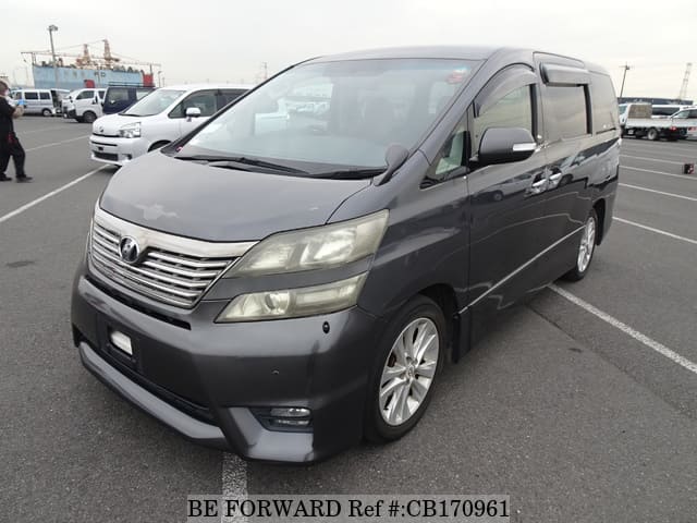 A grey JDM sports car speeding down a highway at night.
