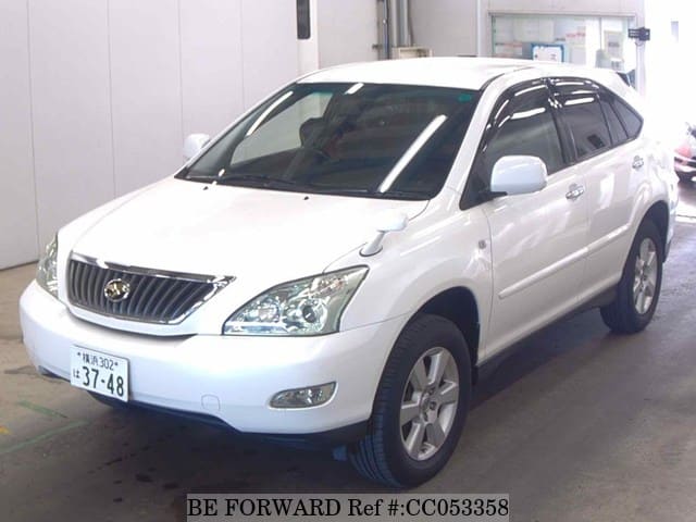 A grey sports car speeding down a highway at night.
