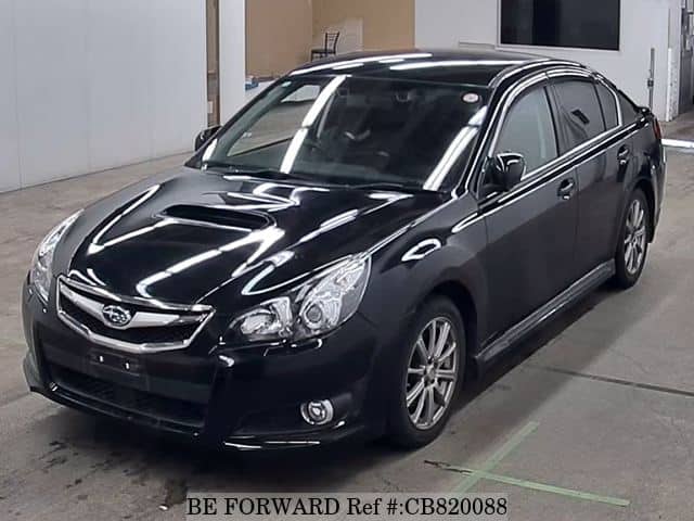 A grey JDM sports car speeding down a highway at night.