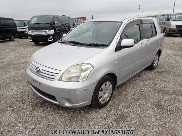 A grey JDM sports car speeding down a highway at night.