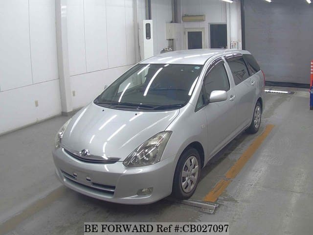 A grey JDM sports car speeding down a highway at night.
