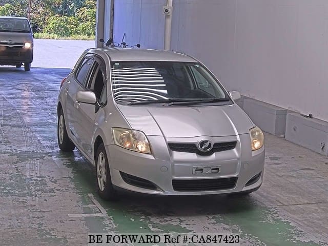 A grey JDM sports car speeding down a highway at night.