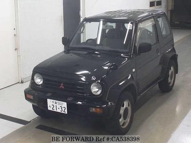 A grey JDM sports car speeding down a highway at night.