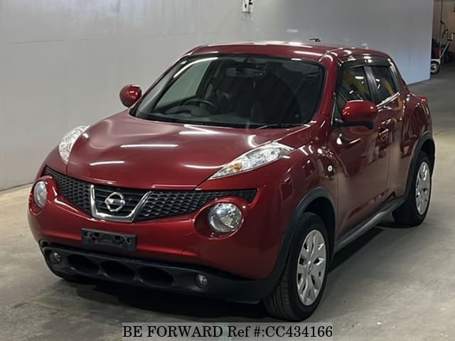 A grey sports car speeding down a highway at night.