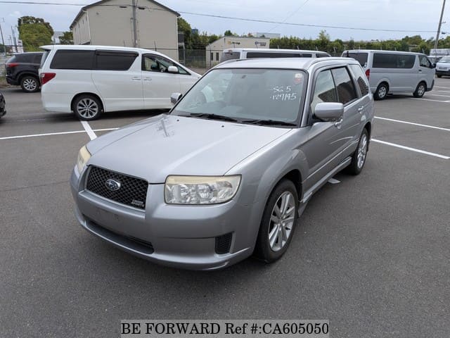 A grey JDM sports car speeding down a highway at night.