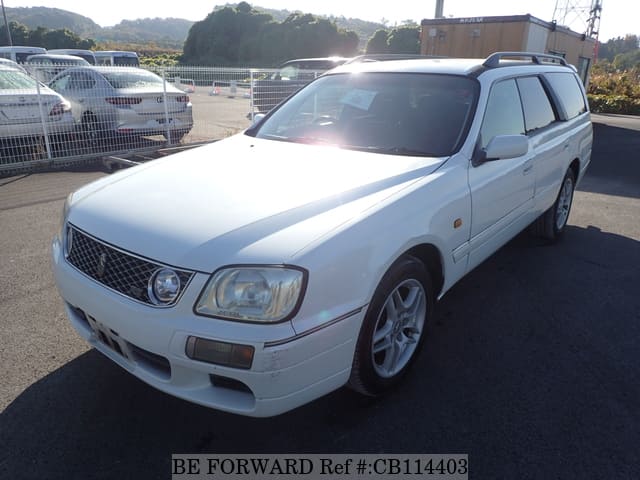 A grey JDM sports car speeding down a highway at night.