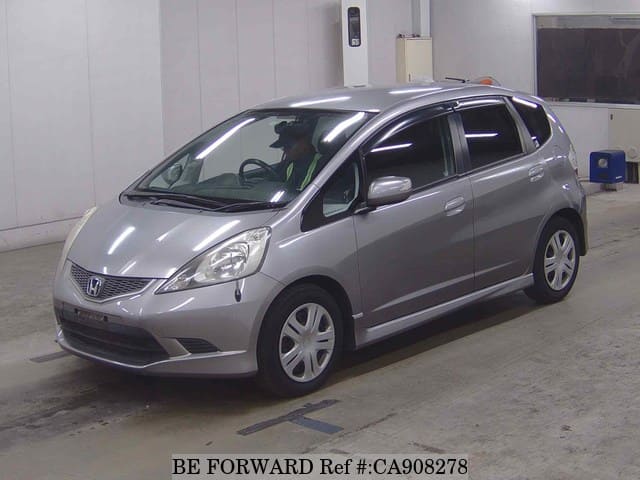 A grey JDM sports car speeding down a highway at night.