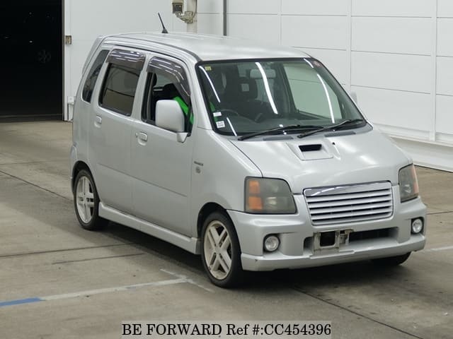 A grey JDM sports car speeding down a highway at night.