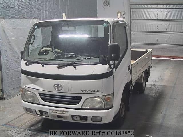 A grey sports car speeding down a highway at night.