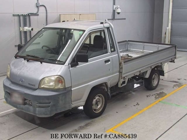 A grey JDM sports car speeding down a highway at night.