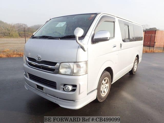 A grey JDM sports car speeding down a highway at night.