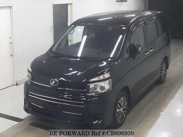 A grey JDM sports car speeding down a highway at night.