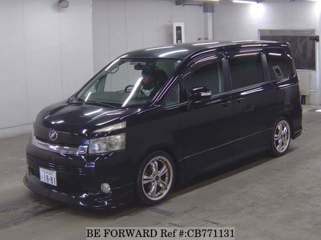 A grey JDM sports car speeding down a highway at night.