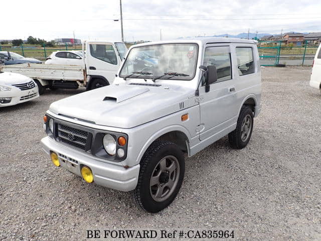 A grey JDM sports car speeding down a highway at night.
