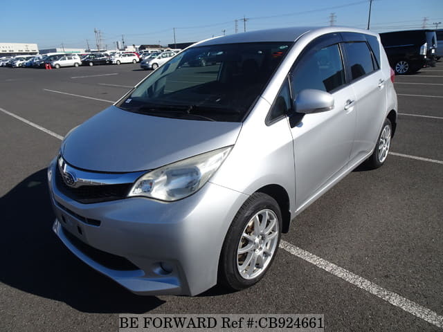A grey sports car speeding down a highway at night.