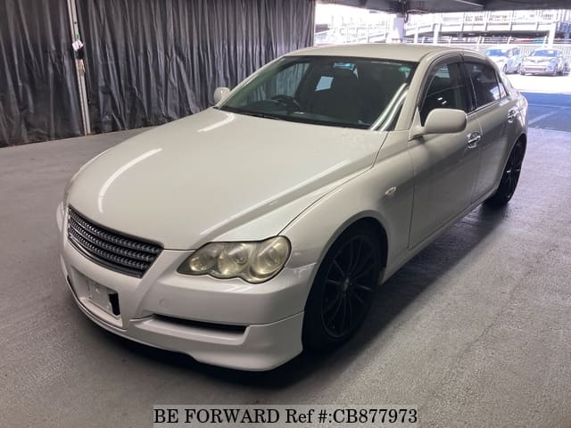 A grey JDM sports car speeding down a highway at night.