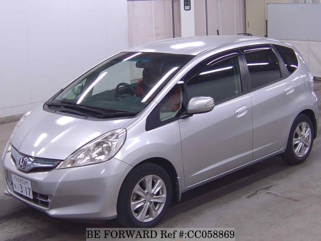 A grey sports car speeding down a highway at night.