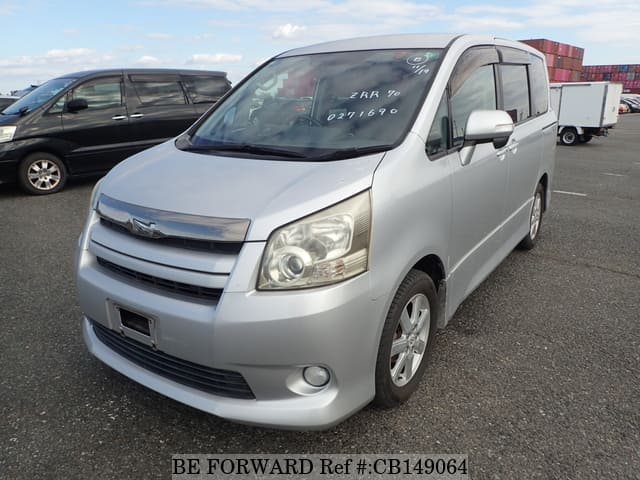 A grey sports car speeding down a highway at night.