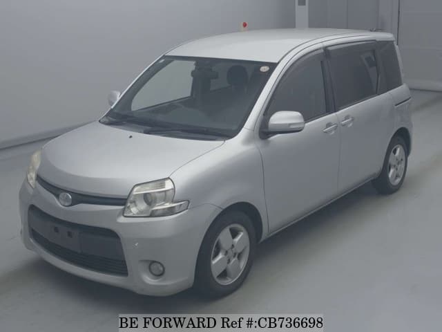 A grey JDM sports car speeding down a highway at night.