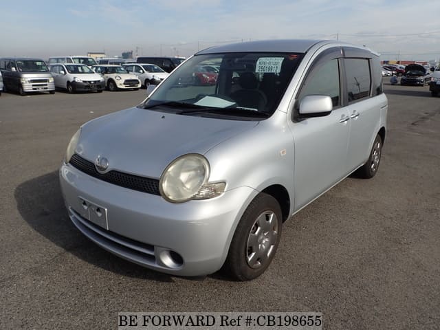 A grey JDM sports car speeding down a highway at night.