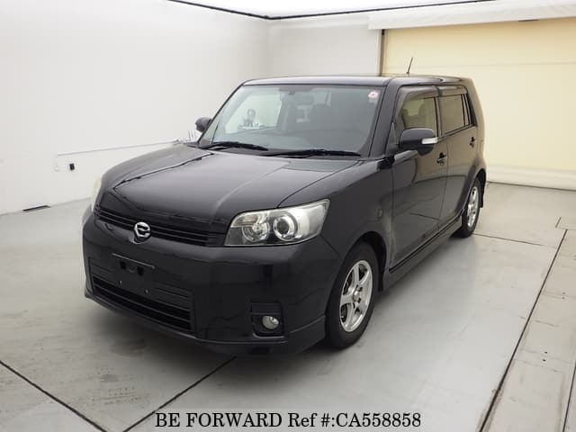 A grey JDM sports car speeding down a highway at night.