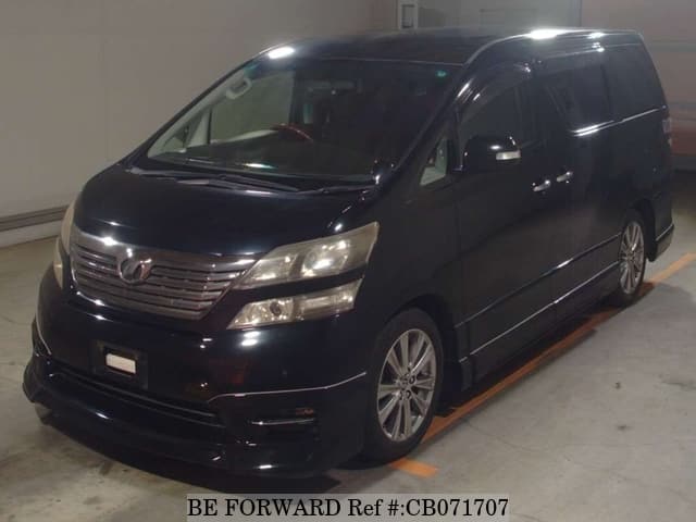 A grey JDM sports car speeding down a highway at night.