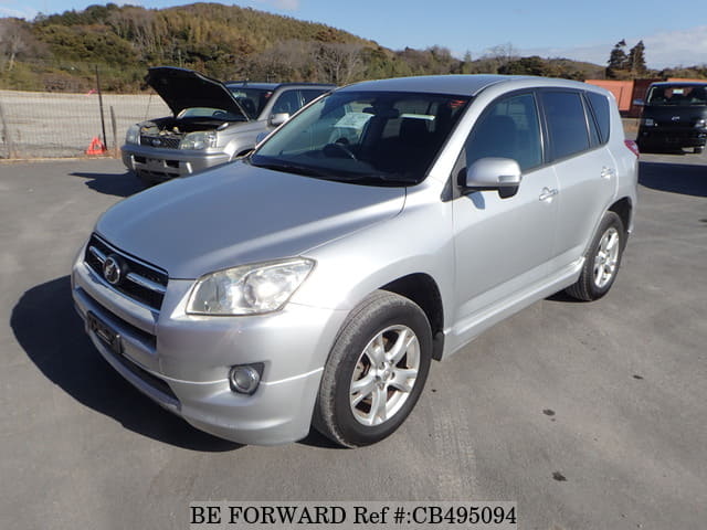 A grey JDM sports car speeding down a highway at night.