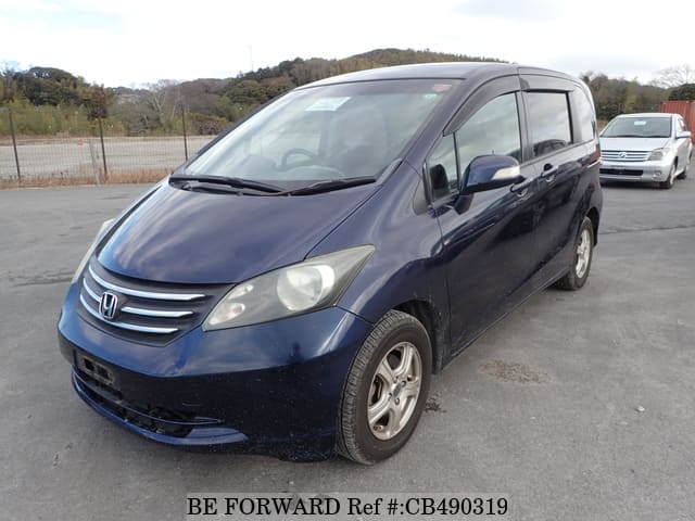 A grey JDM sports car speeding down a highway at night.