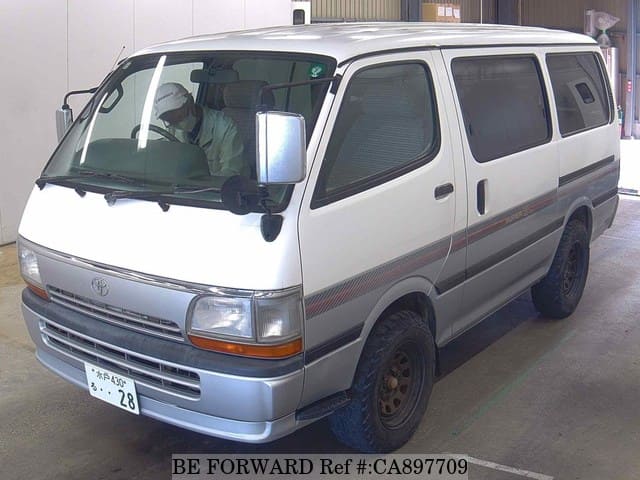 A grey JDM sports car speeding down a highway at night.