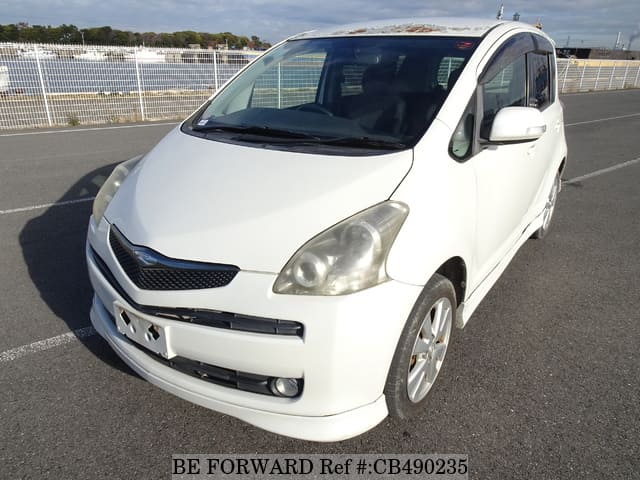 A grey JDM sports car speeding down a highway at night.