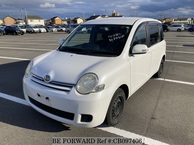 A grey JDM sports car speeding down a highway at night.