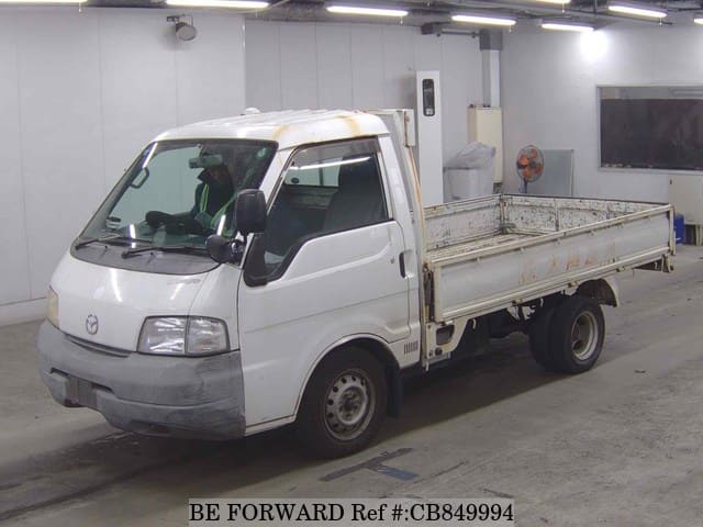 A grey JDM sports car speeding down a highway at night.