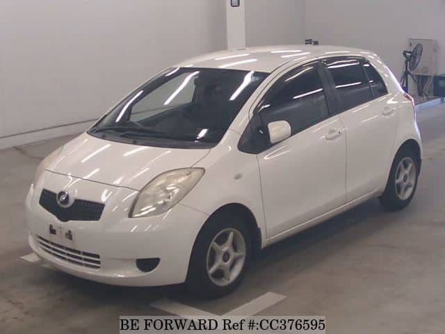 A grey sports car speeding down a highway at night.
