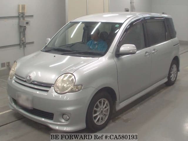 A grey JDM sports car speeding down a highway at night.
